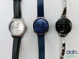 three different styles of watches sitting next to each other on a white surface