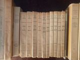 several old books are lined up in a row on a shelf