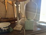 a table with a lamp, a vase, and a sailboat on it