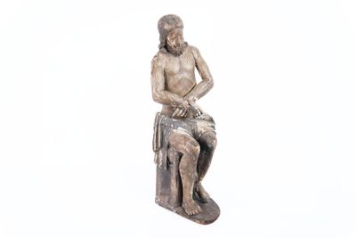 une statue représentant un homme assis sur une caisse