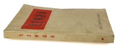 un vieux livre portant des caractères chinois, posé sur une surface blanche