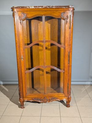 un meuble en bois avec une porte en verre dans une pièce