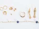 plusieurs paires de boucles d'oreilles, des bracelets et des bagues posés sur un fond blanc