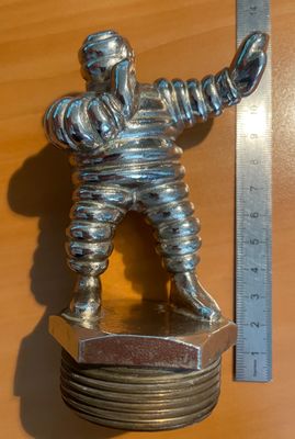une figurine en argent représentant un homme tenant une raquette de tennis posée sur une pile de sous-verres