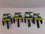 four black and yellow plastic forks are lined up against a white wall