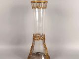 a clear glass vase with gold trimmings on it