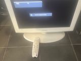 a computer monitor sitting on the floor with a remote control