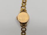 a close up of a gold watch on a white surface