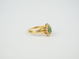 a close up of a gold ring with a green stone