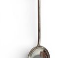 a metal spoon with a metal handle on a white surface