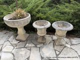 deux jardinières en béton posées sur une terrasse en pierre
