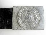 an old belt with a silver buckle on a white surface