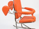 an orange leather chair with a metal frame and arm rests against a white background