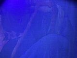 a statue of a man holding a stick in front of a blue light