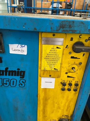 a blue machine with a yellow door and some stickers on it