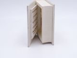 an open book with a white cover sitting on a white surface
