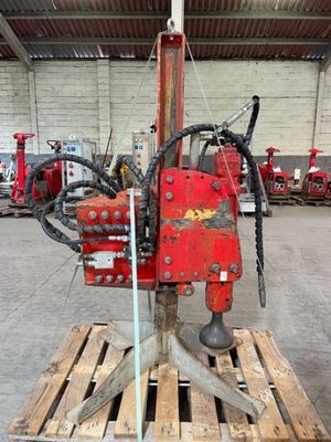 une machine rouge posée sur une palette dans un entrepôt