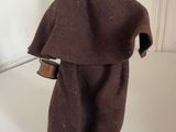 a figurine of a monk with a bell on a table