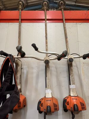cinq outils électriques accrochés au mur d'un garage