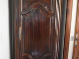 a tall wooden cabinet in the corner of a room
