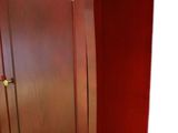 an image of a wooden armoire with a drawer underneath it