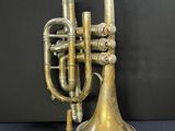 an antique brass trumpet with a brass bell and two brass valves