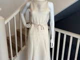 mannequin vêtu d'une robe blanche et d'un chapeau de paille, posé sur un escalier