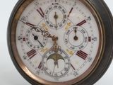 a close up of a pocket watch on a white surface