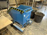 un grand conteneur bleu posé sur un chariot dans une pièce