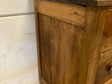 an old wooden dresser with three drawers and a marble top