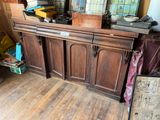 a wooden cabinet with a lot of items on top of it
