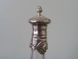 a glass bottle with a silver lid sitting on a table