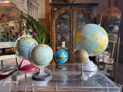 many different types of globes on display in a glass case