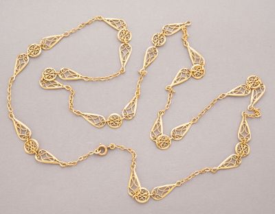 a close up of a gold chain with a knot on it