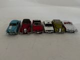 several toy cars are lined up in a row on a white surface