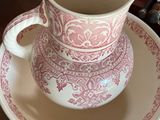 a pink and white cup and saucer on a table