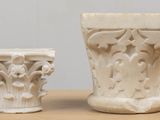 two white vases sitting on a table next to each other