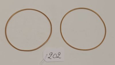 une paire de boucles d'oreilles créoles en or avec une étiquette de prix