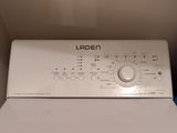 une machine à laver blanche posée dans un coin de la pièce