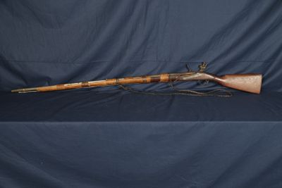 un fusil au canon en bois sur fond bleu