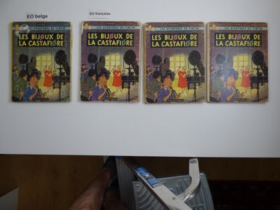 une personne tenant une brosse à dents devant trois livres