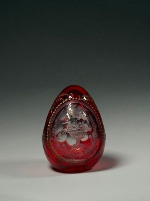 une image représentant un œuf en verre rouge orné d'un dessin de chat