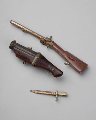 trois types d'armes différents sont exposés sur une surface blanche