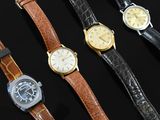 several different types of watches are lined up on a black surface