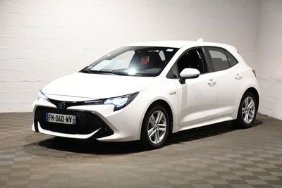 La Toyota Corolla blanche est garée dans une pièce blanche.