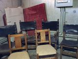 six chairs in a room with a television in the background