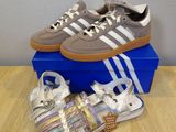 des chaussures et des sandales adidas posées sur une table à côté d'une boîte bleue