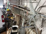 a white van parked in a garage next to a pile of junk
