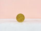 a gold coin sitting on top of a white surface