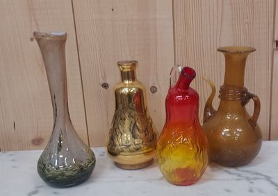 quatre vases de couleurs différentes posés sur une table